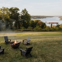 chairs and a fire pit near a body of water
